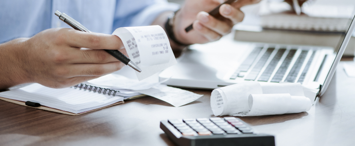 Debts and expenses piling up on table.